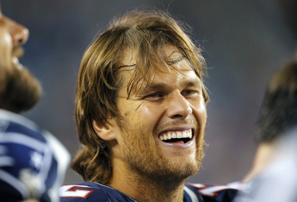 New England Patriots quarterback Tom Brady laughs with his teammates on the sideline during the fourth quarter of their NFL preseason football game against the St. Louis Rams in Foxborough, Massachusetts August 26, 2010. 