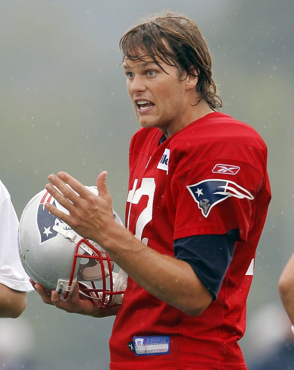 New England Patriots quarterback Tom Brady talks to his teammates and coaches during the first official day of the teams NFL football training camp in Foxborough, Massachusetts July 29, 2010.