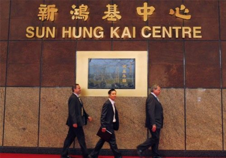 Businessmen walk in front of Sun Hung Kai Properties company's headquarters in Hong Kong