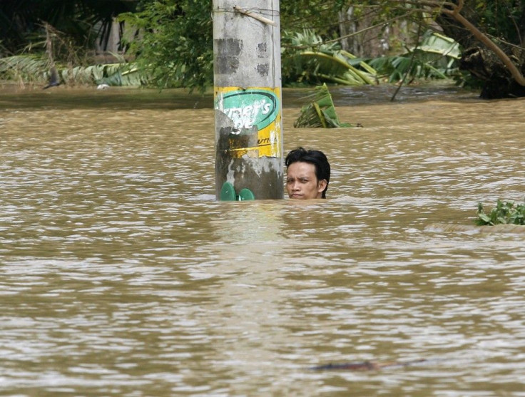 A resident holds onto an electrical post as he takes a rest from swimming in floodwaters brought by Typhoon Nesat in Apalit Pampanga, north of Manila September 29, 2011.