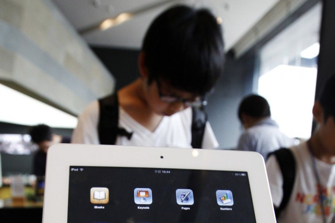 A customer looks at an Apple Inc's iPad 2 tablet at South Korean mobile carrier KT's headquarters in Seoul