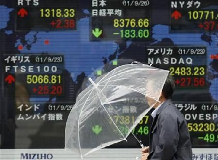 A man walks past a stock quotation board outside a brokerage in Tokyo