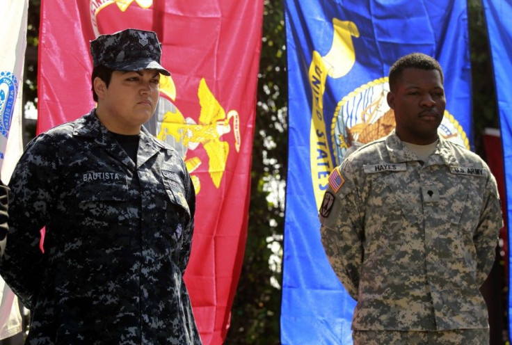 Navy Counselor 1st Class Luz Bautista, who is a lesbian, and Army Specialist William Hayes, who is bisexual, listen to a news conference in Los Angeles