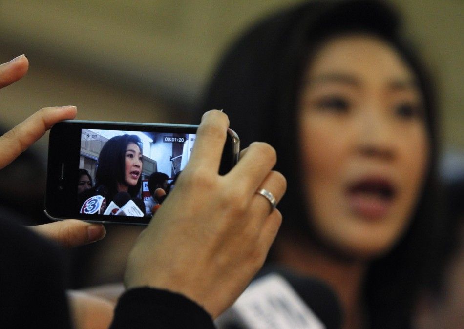  A woman uses her mobile phone to take a picture of Thai PM-elect Yingluck Shinawatra at her partys headquarters in Bangkok