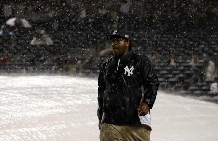 A groundskeeper is pictured during a rain delay in Game 1 of their MLB American League Division Series baseball playoffs between the Yankees and the Tigers in New York