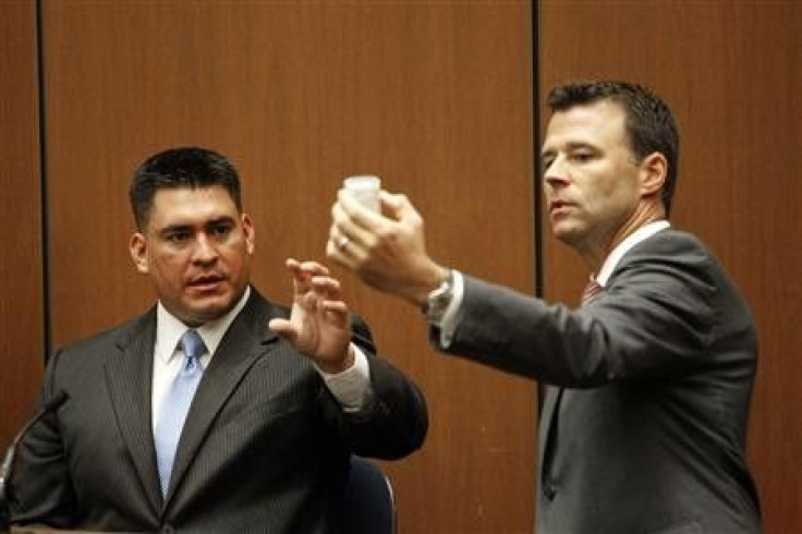 Deputy District Attorney David Walgren (R) holds a bottle of propofol introduced as evidence as he questions Alberto Alvarez (L), one of Michael Jackson's security guards, during Dr. Conrad Murray's trial in the death of pop star Michael Jackson
