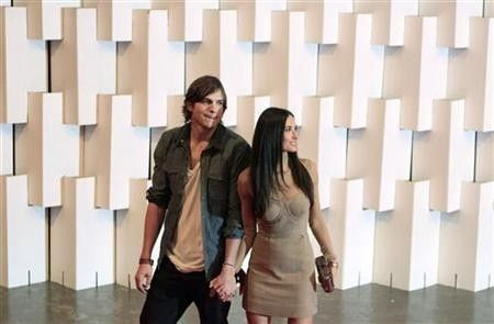 Actor Ashton Kutcher and his wife actress Demi Moore (R) arrive for Colcci's Winter 2011 collection during Sao Paulo Fashion Week