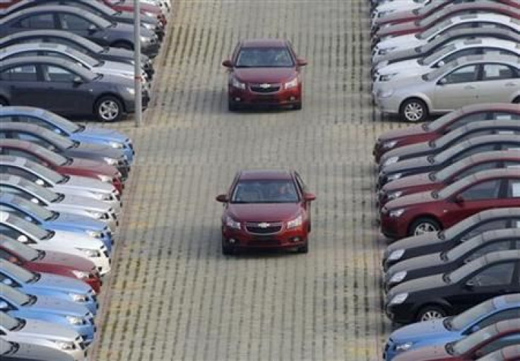 General Motors auto dealership employees drive brand new Chevrolet cars at a parking lot in Shenyang