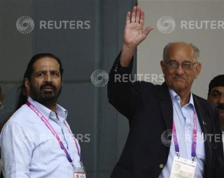 Michael Fennell, president of the Commonwealth Games Federation, waves upon his arrival as the President of the Indian Olympic Association (IOA) and Commonwealth Organising Committee Chairman Suresh Kalmadi watches at the airport in New Delhi September 23