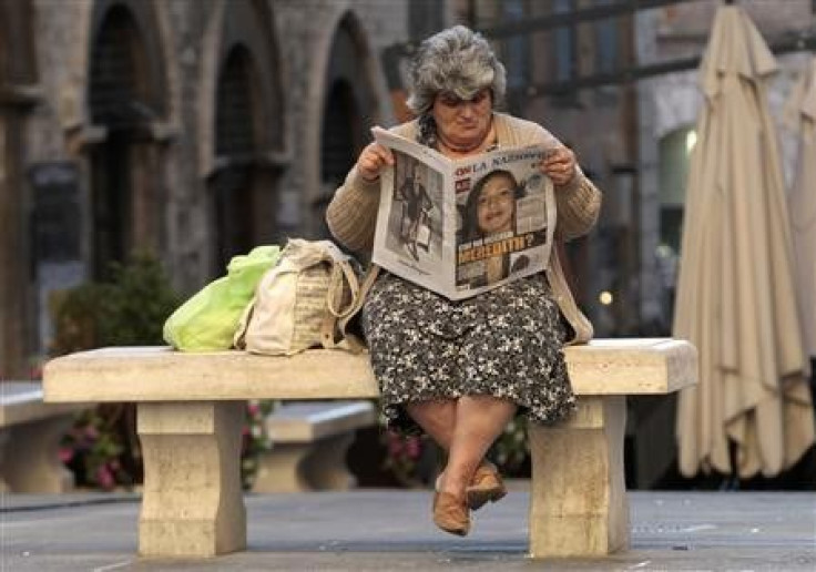 A woman reads a newspaper reading &#039;&#039;Who killed Meredith ?&#039;&#039; in Perugia