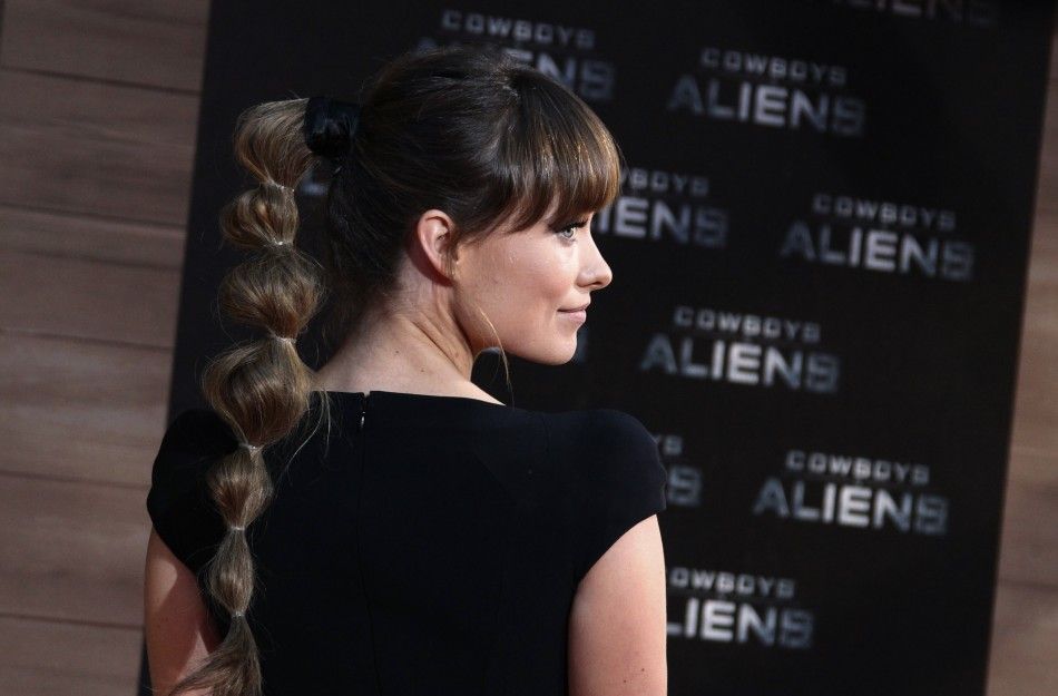 Cast member Olivia Wilde poses for pictures before German premier of the movie Cowboys and Aliens in Berlin