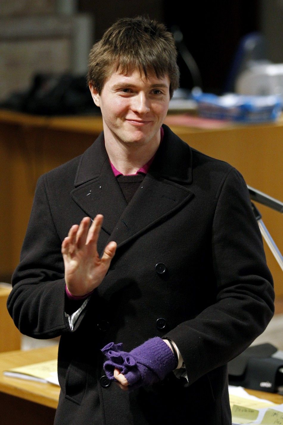 Raffaele Sollecito, the Italian student convicted of killing his British flatmate in Italy three years ago, waves as he returns to the courtroom after a break during a trial session in Perugia 
