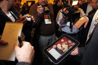 A man displays an unannounced Lenovo tablet computer at a preview of the CES in Las Vegas