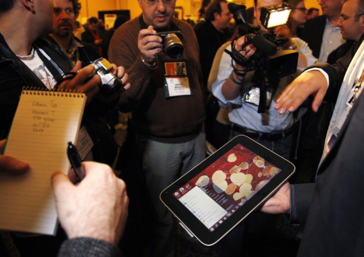 A man displays an unannounced Lenovo tablet computer at a preview of the CES in Las Vegas