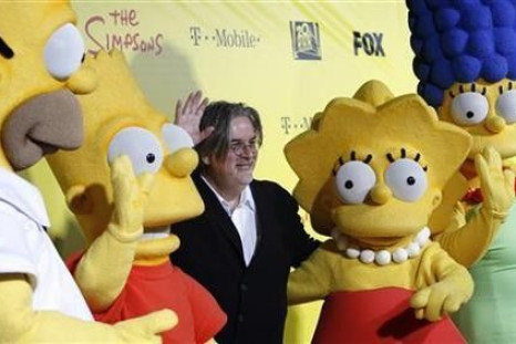 Matt Groening (C), creator of The Simpsons, poses with characters from the show (L-R) Homer, Bart, Lisa and Marge at the 20th anniversary party for the television series at Barker hangar in Santa Monica, California