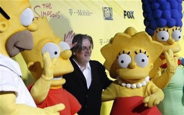 Matt Groening (C), creator of The Simpsons, poses with characters from the show (L-R) Homer, Bart, Lisa and Marge at the 20th anniversary party for the television series at Barker hangar in Santa Monica, California