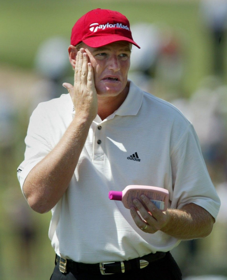 ERNIE ELS APPLIES SUNSCREEN ON THE FIRST HOLE DURING PGA PRACTICE ROUND.