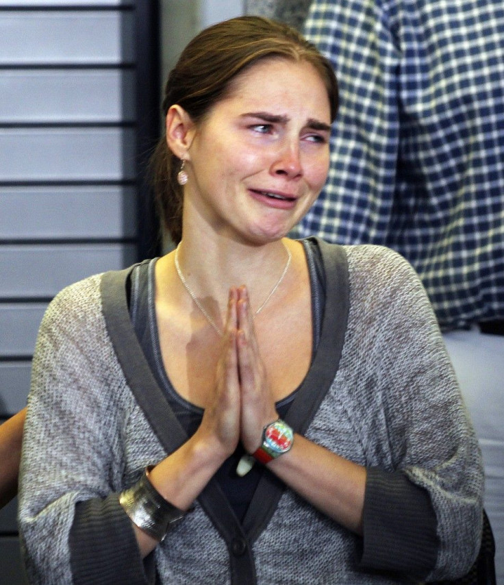 Amanda Knox cries and gestures to friends during a news conference at Sea-Tac International Airport, Washington