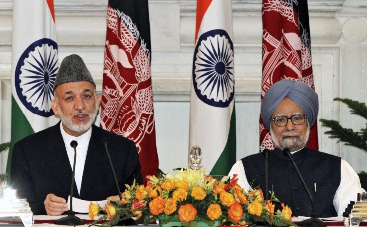 Afghanistan&#039;s President Karzai speaks with the media as India&#039;s Prime Minister Manmohan Singh watches after signing a joint statement at Hyderabad House in New Delhi