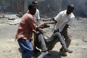 Somali soldiers carry an injured man from the scene of a suicide attack in Mogadishu Oct. 4, 2011.
