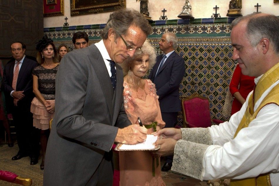 Spains Duchess of Alba Cayetana Fitz-James Stuart y Silva looks on as her husband Alfonso Diez sign a document during their wedding ceremony in Seville