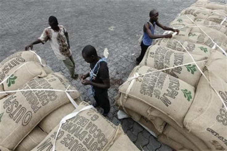 Workers prepare to load sacks of cocoa onto a ship at the port of Abidjan