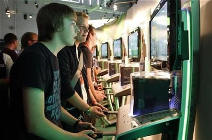 Visitors play the Xbox at the Microsoft exhibition stand during the Gamescom 2011 fair in Cologne