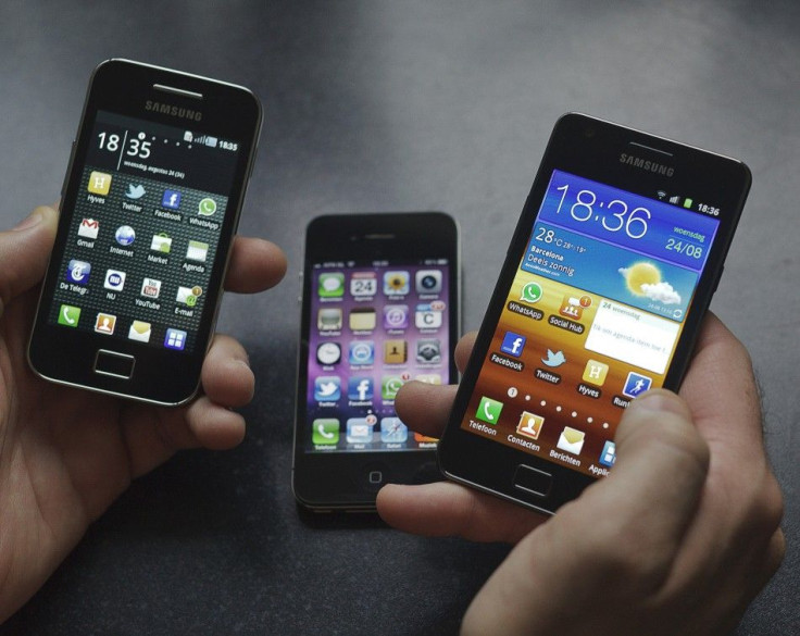 A man holds a Samsung S II and a Samsung Ace next to an Apple iPhone 4. Samsung may end up releasing its two iPhone killers in October, the same month Apple plans to release the iPhone 4S.