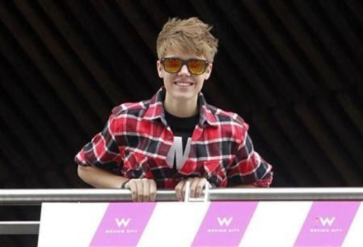 Canadian pop singer Justin Bieber greets his fans from the balcony of his hotel in Mexico City