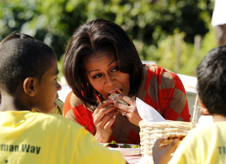 U.S. first lady Michelle Obama eats a pizza made with vegetables harvested from the White House Kitchen Garden during the fall season harvesting event in Washington