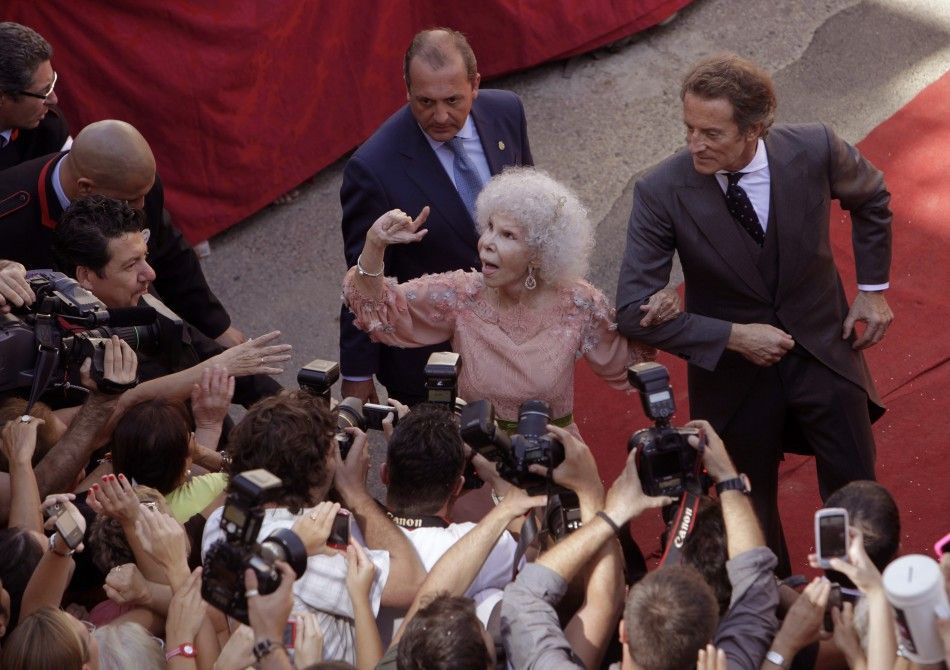Spains Duchess of Alba Cayetana Fitz-James Stuart y Silva L and her husband Alfonso Diez greet the crowd outside Las Duenas Palace after their wedding in Seville 
