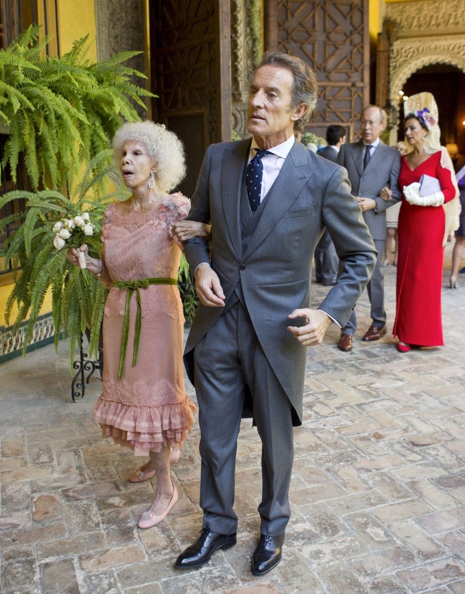 Spains Duchess of Alba Cayetana Fitz-James Stuart y Silva L and her husband Alfonso Diez walk inside Las Duenas Palace after their wedding ceremony in Seville