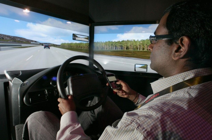 A man texts on his mobile phone while driving in a simulator during the 2010 International CES in Las Vegas