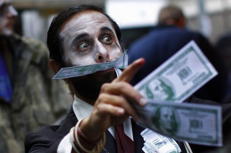 A demonstrator carries play money while dressed as a &quot;corporate zombie&quot; as he walks with others taking part in an Occupy Wall Street protest in lower Manhattan in New York