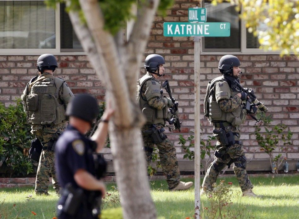 Police officers search a suburban street during a manhunt in Sunnyvale, California