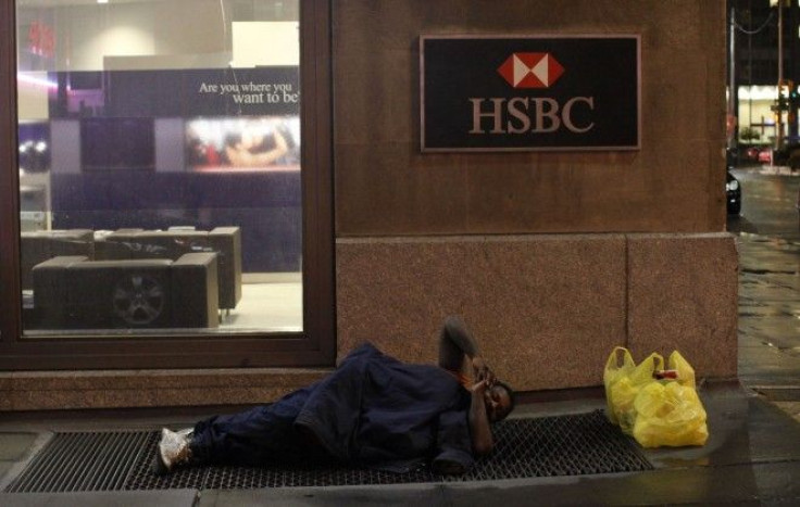 A homeless man sleeps on a street outside a branch of HSBC bank in New York