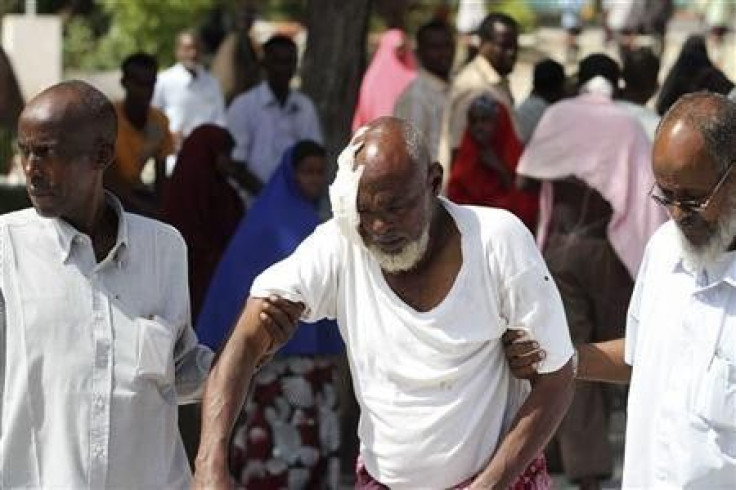 People assist a man wounded in a suicide blast in Mogadishu