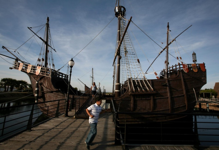 Boy runs next to replica of caravel which Cristobal Colon used to discover America are berthed in La Rabida