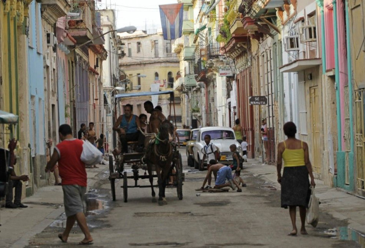 People walk as children play on a street in Havana, Cuba
