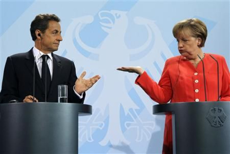 French President Nicolas Sarkozy (L) and German Chancellor Angela Merkel gesture as they address a news conference at the Chancellery in Berlin
