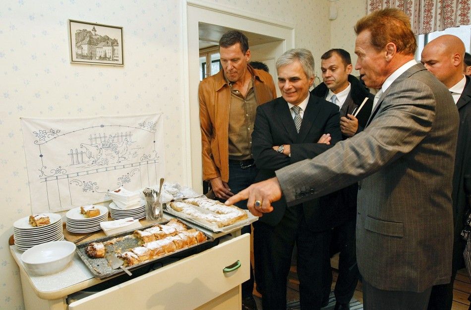 Austrian actor, former champion bodybuilder and former California governor Arnold Schwarzenegger R looks at apple strudel next to Austrian Chancellor Werner Faymann 2nd L and German actor Ralf Moeller L as they tour inside Schwarzeneggers former ho
