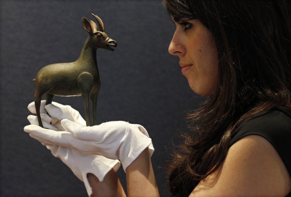 Christies Islamic art specialist Sara Plumbly holds a Fatimid bronze gazelle at Christies in London