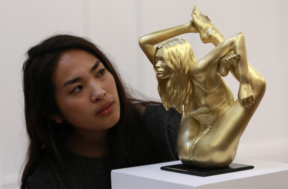 A Sothebys employee poses with an 18 carat gold sculpture of Kate Moss entitled quotMicrocosmos Sirenquot by Marc Quinn