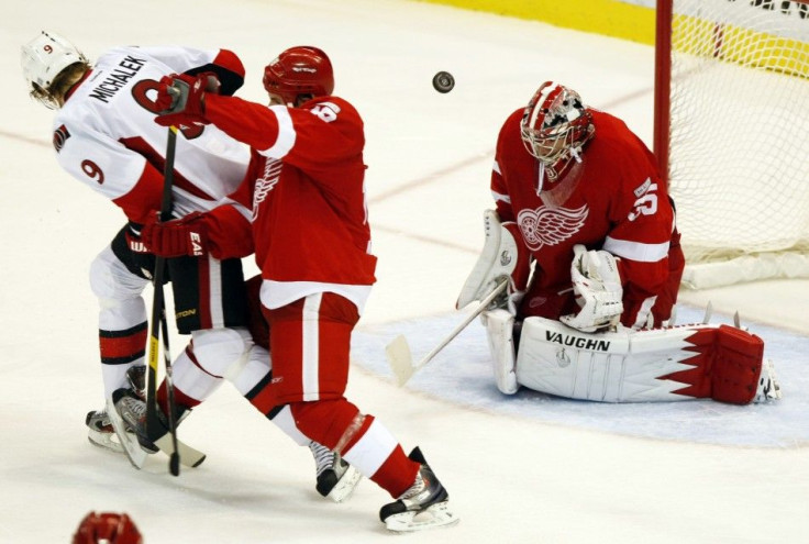 Ottawa Senators left wing Milan Michalek watches his shot fly past Detroit Red Wings defenseman Ian White and over goalie Jimmy Howard to score during the third period of their NHL hockey game in Detroit