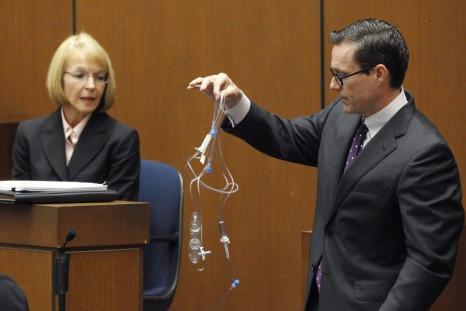 Defense attorney Ed Chernoff holds an IV line as he questions prosecution witness Sally Hirschberg during Dr. Conrad Murray's trial in Los Angeles