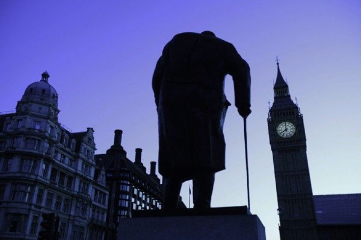 The Big Ben clock and a statue of former British Prime Minister Winston Churchill are silhouetted against the morning sky in central London