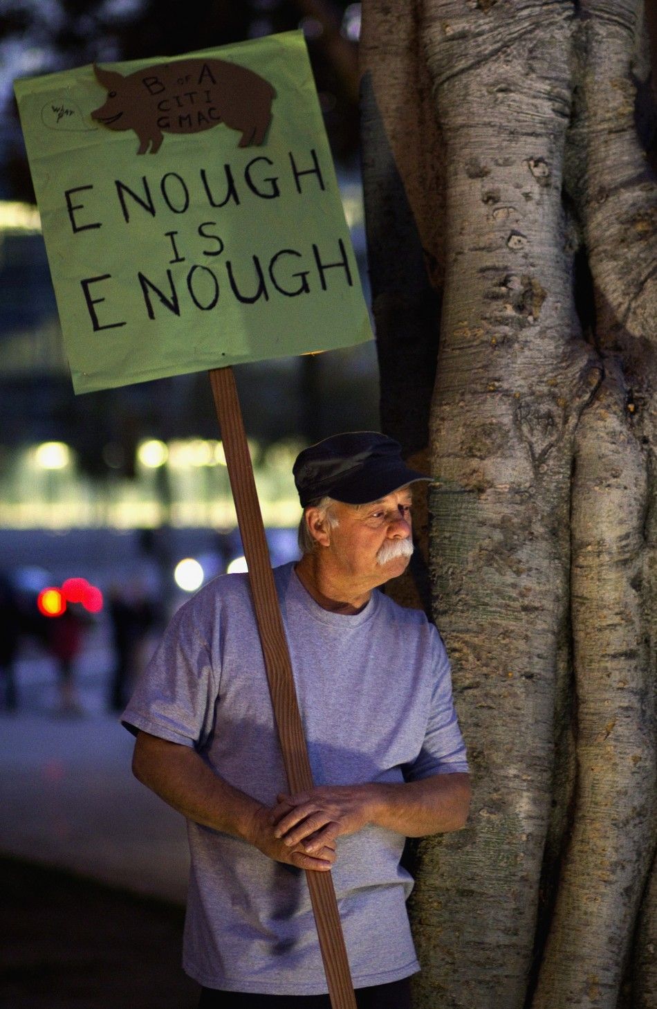 A demonstrator holds a sign at the Occupy LA protest on the lawn in front of Los Angeles City Hall