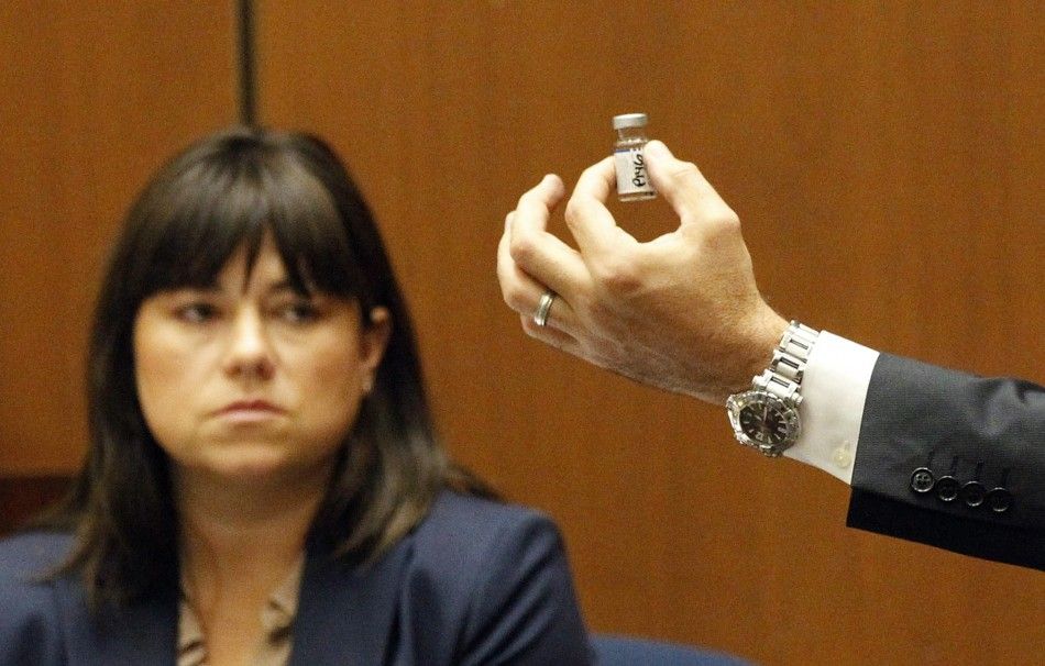Deputy District Attorney David Walgren holds a bottle found by Los Angeles County coroner investigator Elissa Fleak L during her testimony at Dr. Conrad Murrays trial in pop star Michael Jacksons death in Los Angeles