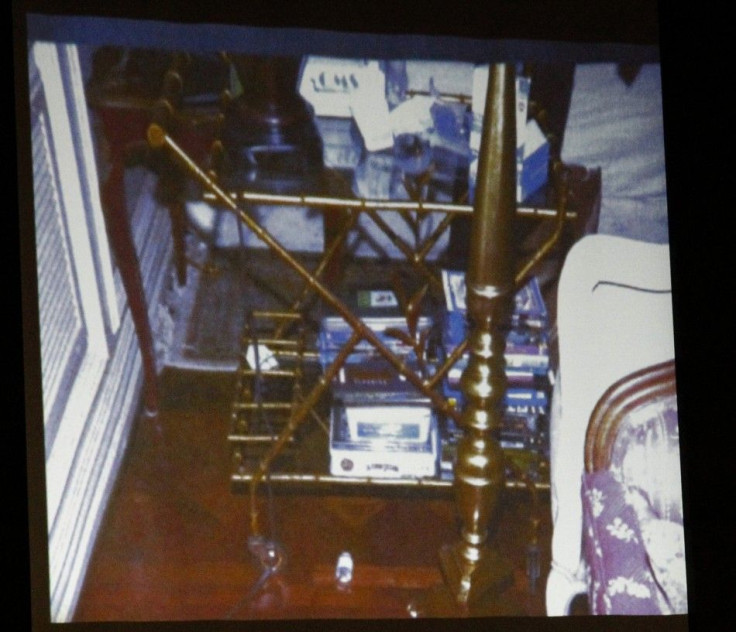 A bottle of propofol lies under a side table found in the bedroom of Michael Jackson in this photo projected on a screen during Dr. Conrad Murray's trial
