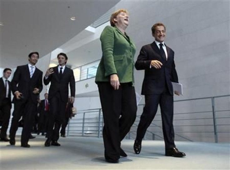 French President Sarkozy and German Chancellor Merkel arrive to address a news conference at the Chancellery in Berlin